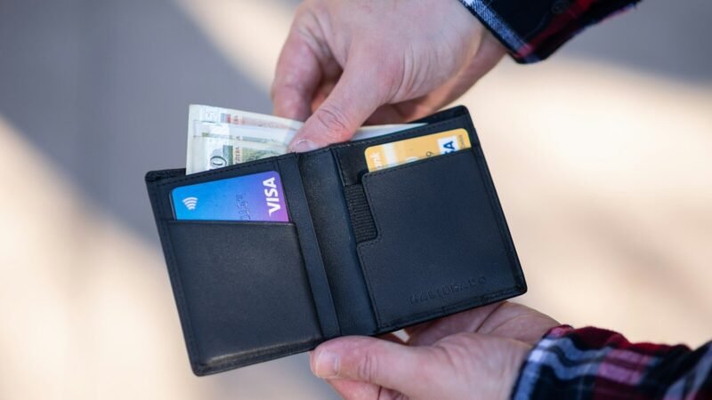 black leather bifold wallet on persons hand