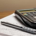 A detailed view of a calculator and pen resting on mathematical notes, ideal for educational and financial themes.