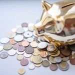 A golden piggy bank surrounded by assorted coins, symbolizing savings and wealth.